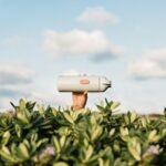 white and black speaker on green plants during daytime